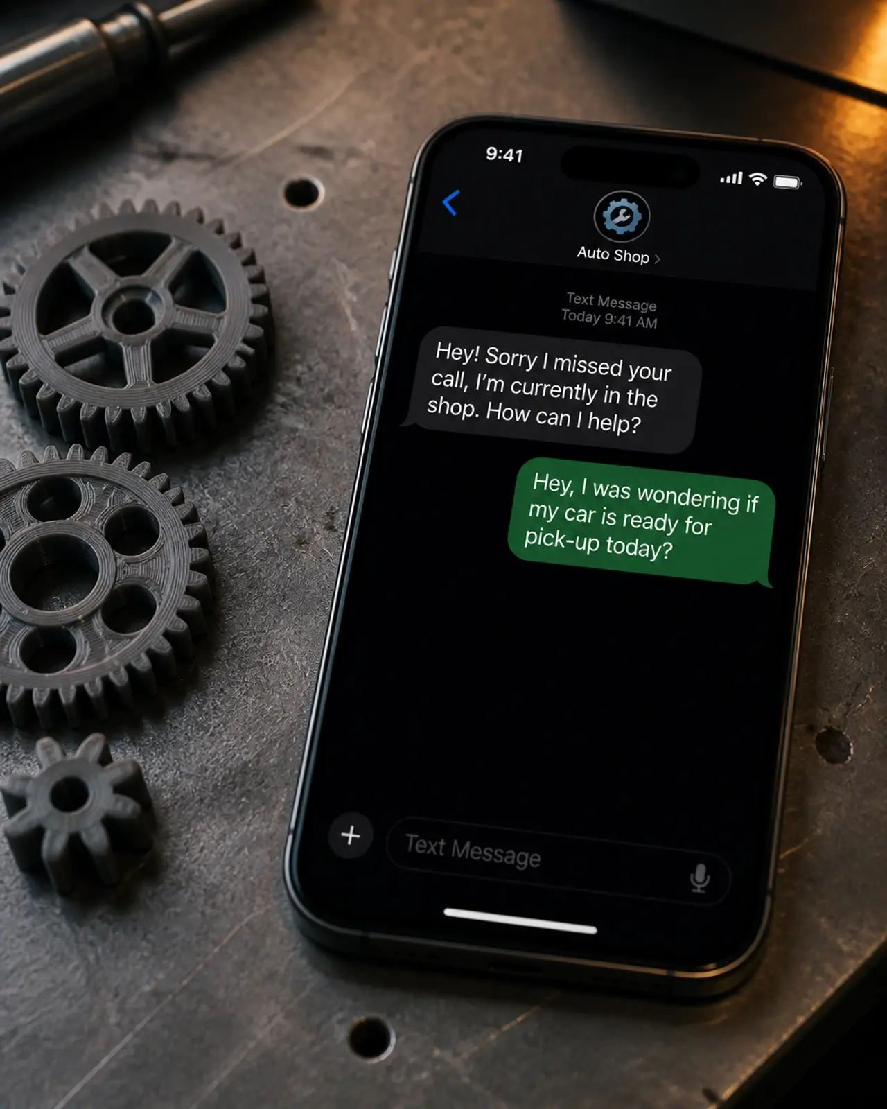 A close-up of a smartphone getting an automated text reply on a metal workbench