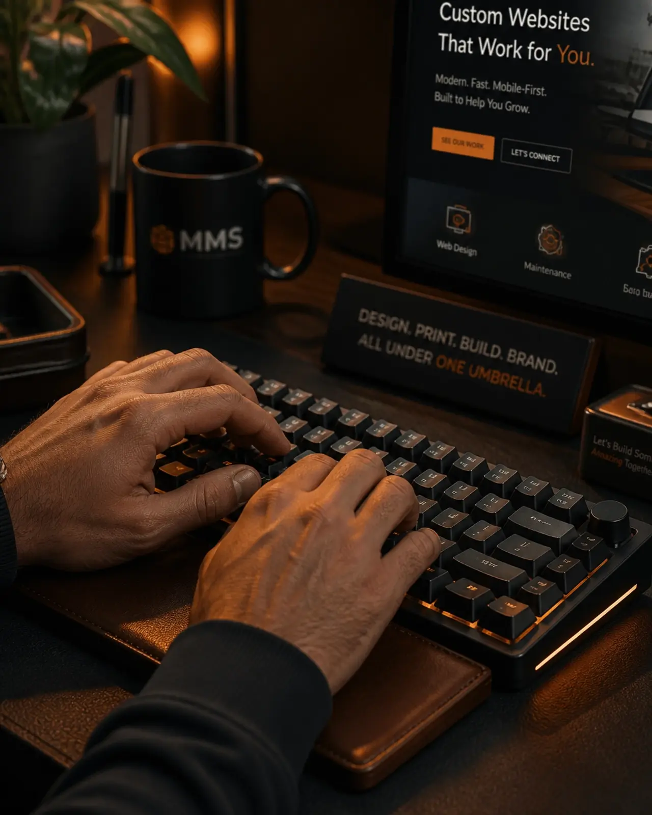 Close-up of hands typing on a modern keyboard in a warm, dark-themed home office environment